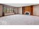 Spacious living room with fireplace, built-in shelving, large window and neutral carpet at 6744 Robin Hood Ct, Indianapolis, IN 46227