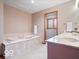 Relaxing bathroom with soaking tub, single vanity, tile surround and natural light at 6744 Robin Hood Ct, Indianapolis, IN 46227