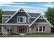 Charming two-story home featuring a brick facade, inviting front porch, and gable roof design at 6887 Oakdale Ln, Avon, IN 46123