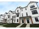 Charming townhomes featuring a white exterior, black-trimmed windows, covered entryway and landscaped front yard at 7081 Pate Hollow Dr, Brownsburg, IN 46112