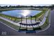 Aerial view of a pond surrounded by greenery, featuring walking trails and inviting pergola at 7081 Pate Hollow Dr, Brownsburg, IN 46112