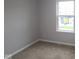 This bedroom features neutral carpet, grey walls, and a bright window for natural light at 7089 Pate Hollow Dr, Brownsburg, IN 46112