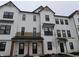 Modern townhome featuring a white exterior, black trim, and covered entrances with wood accents at 7089 Pate Hollow Dr, Brownsburg, IN 46112