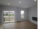 Bright living room with wood flooring, sliding door to balcony, and a modern fireplace at 7089 Pate Hollow Dr, Brownsburg, IN 46112