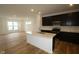 Modern kitchen with black cabinets, white countertops, stainless-steel appliances, and wood floors at 7093 Pate Hollow Dr, Brownsburg, IN 46112