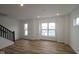 Bright living area with wood floors, natural light, and a staircase on the left at 7093 Pate Hollow Dr, Brownsburg, IN 46112