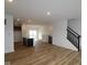 Open-concept living space with wood floors flows into a modern kitchen and staircase at 7093 Pate Hollow Dr, Brownsburg, IN 46112