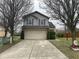 Two-story home with a wide driveway leading to a two-car garage at 8033 Lake Tree Cir, Indianapolis, IN 46217