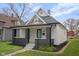 Charming home featuring a peaked gable roof, gray brick accents, and a well maintained yard at 843 N Oxford St, Indianapolis, IN 46201