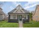 Charming home featuring a peaked gable roof, gray brick accents, and a freshly manicured front lawn at 843 N Oxford St, Indianapolis, IN 46201