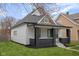 Charming home featuring a peaked gable roof, gray brick accents, and a well maintained yard at 843 N Oxford St, Indianapolis, IN 46201