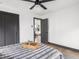 Bedroom featuring a ceiling fan, minimalist decor, wood floors, and gray baseboards at 928 E Pleasant Run Parkway North Dr, Indianapolis, IN 46203