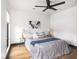 Modern bedroom featuring a ceiling fan, light hardwood floors, and neutral wall art at 928 E Pleasant Run Parkway North Dr, Indianapolis, IN 46203