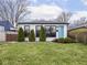 Charming white brick home featuring a bright blue front door and manicured landscaping at 928 E Pleasant Run Parkway North Dr, Indianapolis, IN 46203