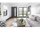 Bright living room with large windows, gray sofa, and natural wood accents at 928 E Pleasant Run Parkway North Dr, Indianapolis, IN 46203