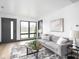 Living room featuring large windows, a gray sofa, and natural wood accents at 928 E Pleasant Run Parkway North Dr, Indianapolis, IN 46203