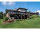 Expansive backyard with multi-tiered deck, hot tub, and lush landscaping on a sunny day at 9398 W Mirror Rd, Columbus, IN 47201