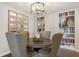 Dining room features modern lighting, neutral paint and a built-in bookcase, providing an elegant dining space at 9398 W Mirror Rd, Columbus, IN 47201