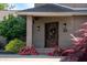 Close-up of the front door with brick columns, ambient lighting, and colorful rose bushes at 9398 W Mirror Rd, Columbus, IN 47201