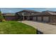 Brick home featuring a three-car garage, expansive driveway, and manicured lawn at 9398 W Mirror Rd, Columbus, IN 47201