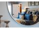 A glimpse of a luxurious main bedroom with a stylish headboard reflected in a round mirror at 9398 W Mirror Rd, Columbus, IN 47201