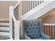 Elegant staircase with white railing, black spindles, and a stylish blue armchair at 9398 W Mirror Rd, Columbus, IN 47201