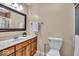 Neutral bathroom featuring a wood vanity, white countertop, decorative mirror and tiled walk-in shower at 9715 Mallery Dr, Noblesville, IN 46060