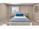 Cozy bedroom showcasing a bed with blue accents, complementing lamps, carpeted floor and natural light at 9715 Mallery Dr, Noblesville, IN 46060