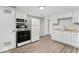 The well-lit kitchen offers bright white cabinetry, modern appliances, and beautiful flooring at 1049 N Traub Ave, Indianapolis, IN 46222