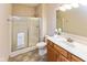 Neutral bathroom featuring a shower with glass doors, white toilet, and sink with a wood cabinet at 1114 Woodridge, Brownsburg, IN 46112