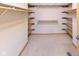 Large walk-in closet with carpet flooring and built-in shelving provides ample storage space at 1114 Woodridge, Brownsburg, IN 46112