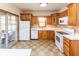 Functional kitchen with wood cabinetry, white appliances, and sliding glass door at 1114 Woodridge, Brownsburg, IN 46112
