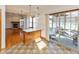 Open kitchen view showcasing breakfast bar, dining area, and sunroom with abundant natural light at 1114 Woodridge, Brownsburg, IN 46112