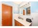 Clean bathroom featuring a sink with wood cabinets, a mirror with lights, and white paneled walls at 1400 W Cowing Dr, Muncie, IN 47304