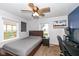 Comfortable bedroom featuring a wooden bed frame, a ceiling fan, two windows, and a built-in desk at 1400 W Cowing Dr, Muncie, IN 47304