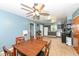 The dining area has a ceiling fan, wooden table and chairs, and is open to the kitchen at 1400 W Cowing Dr, Muncie, IN 47304