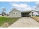 Charming home featuring three windows, an attached carport, and a concrete driveway at 1400 W Cowing Dr, Muncie, IN 47304