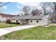 Charming single-story home featuring a stone facade, light green siding, and a well-maintained front lawn at 1400 W Cowing Dr, Muncie, IN 47304