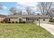 Well-maintained single-story home with stone and light green siding, featuring a neat lawn and mature shrubbery at 1400 W Cowing Dr, Muncie, IN 47304