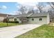 Well-kept single-story home featuring a combination of stone and siding and a neatly kept lawn at 1400 W Cowing Dr, Muncie, IN 47304