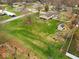A high angle shot shows a green lawn, a back shed, and a garden with raised beds at 1418 E Maple Dr, Shelbyville, IN 46176