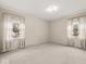 Bright bedroom with carpet and two large windows with decorative drapes at 1418 E Maple Dr, Shelbyville, IN 46176