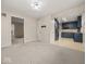 A spacious dining room features neutral paint, gray carpet, and flows into the kitchen at 1418 E Maple Dr, Shelbyville, IN 46176