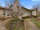 Charming stone home featuring a well-maintained lawn and inviting front entrance with budding spring flowers at 1418 E Maple Dr, Shelbyville, IN 46176