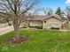 Charming single story home featuring stone accents, well maintained landscaping, and mature trees in the front yard at 1418 E Maple Dr, Shelbyville, IN 46176