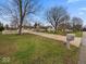 Inviting home with a long driveway, well-manicured lawn, mature trees, and classic mailbox at 1418 E Maple Dr, Shelbyville, IN 46176