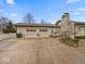 Spacious two-car garage and stone chimney, complemented by a well-kept driveway and landscaped front yard at 1418 E Maple Dr, Shelbyville, IN 46176