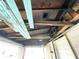 Interior view showing exposed ceiling joists, damaged walls and floors at 1437 Kappes St, Indianapolis, IN 46221
