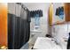 Cozy bathroom featuring a shower with a black curtain and a window, plus classic tiled walls at 15 N Fleming St, Indianapolis, IN 46222