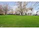 Spacious backyard with lush green grass, mature trees, and a view of the home's exterior at 15638 River Birch Rd, Westfield, IN 46074